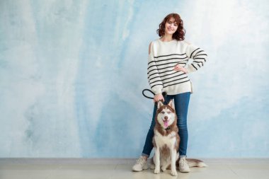 Onun sevimli köpek renk duvarının yakınında olan kadın