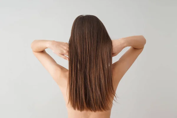 Mladá žena s krásnými dlouhými vlasy na bílém pozadí — Stock fotografie