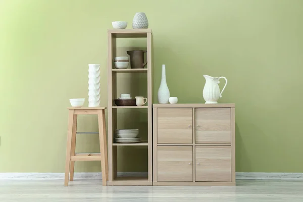 Dřevěný nábytek s čisté nádobí barevné zdi v kuchyni — Stock fotografie