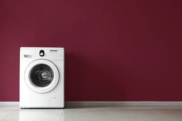 Máquina de lavar roupa moderna perto da parede de cor — Fotografia de Stock