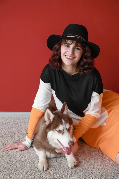 Young woman with her cute dog near color wall — Stock Photo, Image