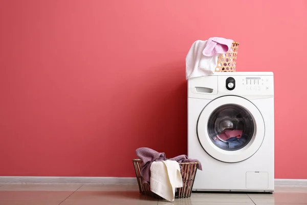 Modern çamaşır makinesi ve çamaşır renk duvarının yakınında — Stok fotoğraf
