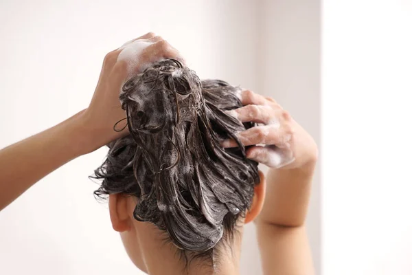 Jovem mulher lavando o cabelo no banheiro — Fotografia de Stock