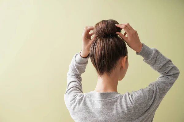 Young woman with hair bun on color background — Stock Photo, Image