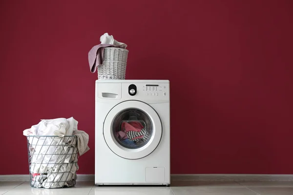 Lavadora moderna y lavandería cerca de la pared de color — Foto de Stock