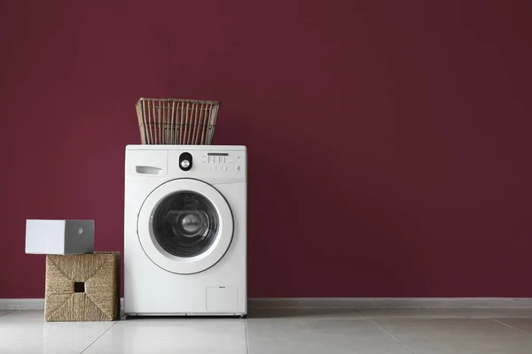 Lavadora moderna y lavandería cerca de la pared de color — Foto de Stock