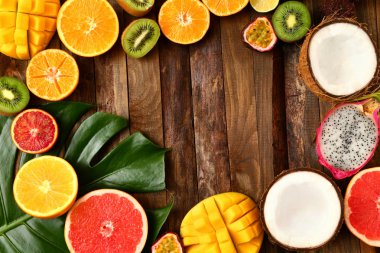 Ahşap arka plan üzerinde tropikal meyvelerin çerçeve yaptı