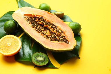 Renk arka plan üzerinde tropikal yaprak ile lezzetli egzotik meyve çeşitleri