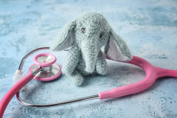Sevimli fil oyuncak renk arka plan üzerinde stetoskop ile. Sağlık bakım çocuklar için — Stok fotoğraf