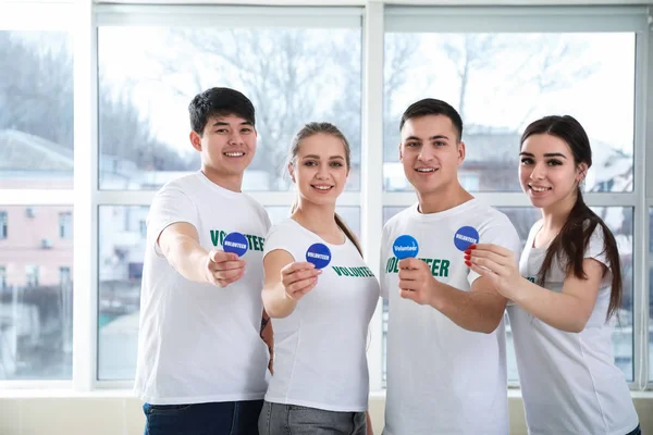 Grupo de jóvenes voluntarios con placas en el interior — Foto de Stock