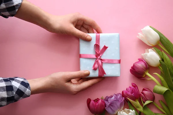 선물 상자와 컬러 바탕에 아름 다운 꽃 여성 손 — 스톡 사진