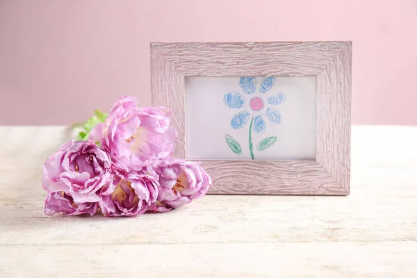 Frame met foto van mooie bloem en tulpen op witte tafel — Stockfoto