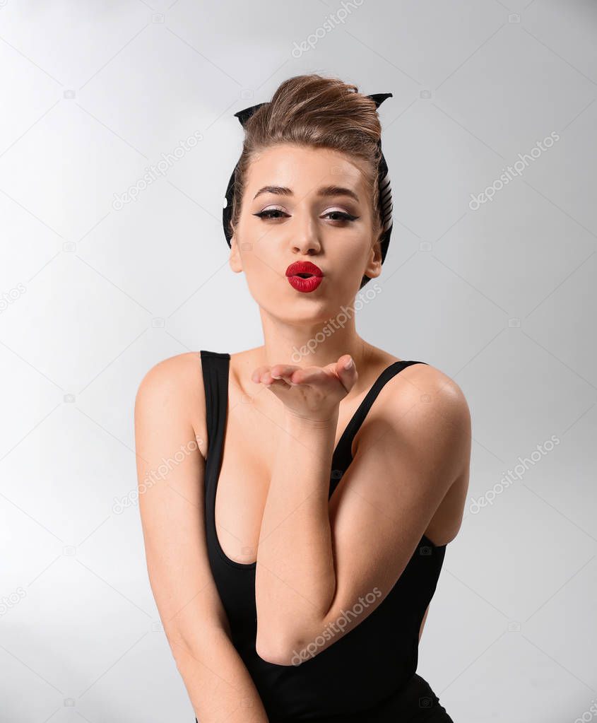 Playful pin-up woman on grey background