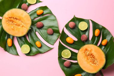 Renk arka plan üzerinde tropikal yaprakları ile lezzetli egzotik meyve çeşitleri
