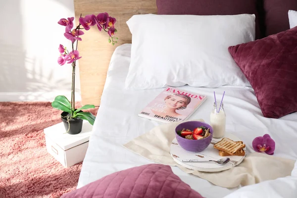 Tray with healthy breakfast and magazine on bed — Stock Photo, Image