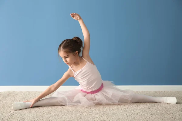 Schattige kleine ballerina rekken in de buurt van kleur muur — Stockfoto