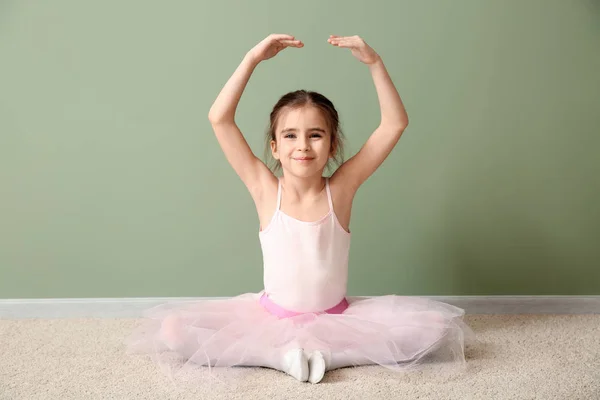 Niedliche kleine Ballerina sitzt in der Nähe der Farbwand — Stockfoto
