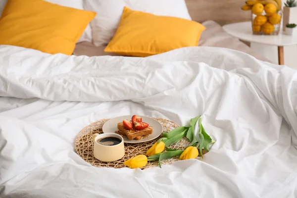 Savoureux petit déjeuner sain et fleurs sur le lit — Photo