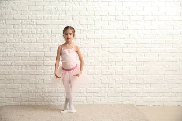 Cute little ballerina near white brick wall — Stock Photo, Image