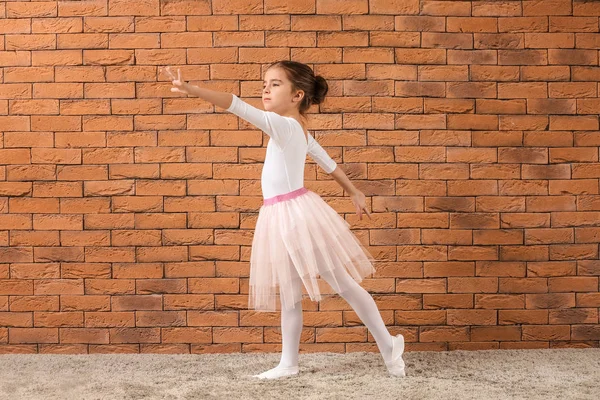 Cute little ballerina against brick wall — Stock Photo, Image