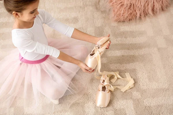 Sevimli küçük balerin evde noktası ayakkabı üzerinde koyarak — Stok fotoğraf