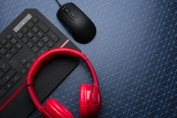 Modern gaming keyboard, mouse and headphones on table