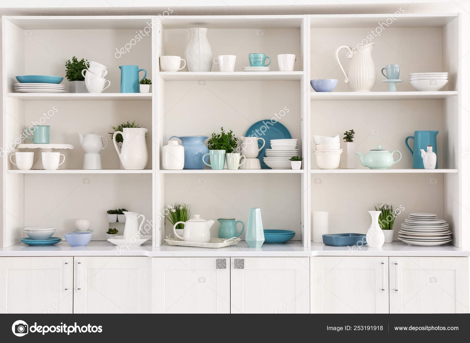 Open cupboard with clean dishes in kitchen — Stock Photo
