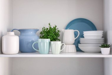 Shelf with clean dishes in kitchen clipart
