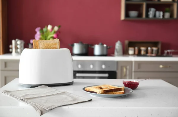 Toaster with bread and jam on table in kitchen — Stock Photo, Image