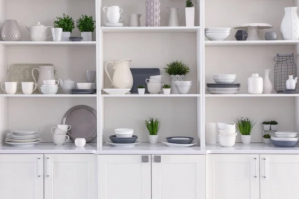 Open cupboard with clean dishes in kitchen — Stock Photo, Image