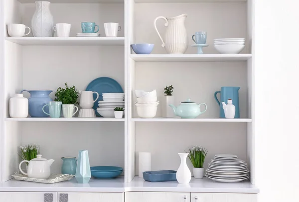 Open cupboard with clean dishes in kitchen — Stock Photo, Image