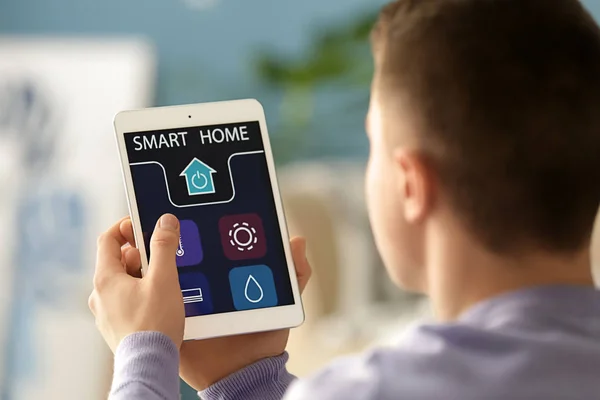 Teenage boy using application of smart home automation — Stock Photo, Image