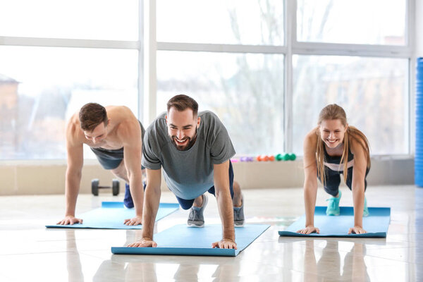Sporty young people training in gym