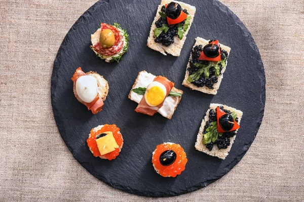 Tasty canapes on slate plate — Stock Photo, Image