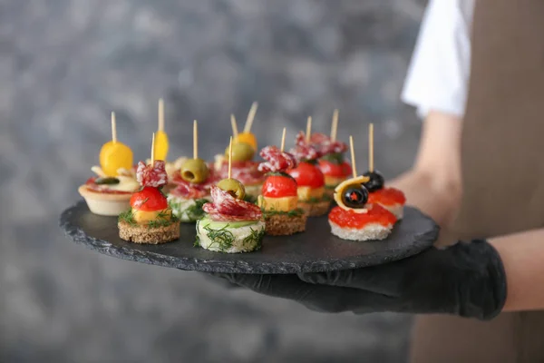 Chef holding slate plate with tasty canapes, closeup — Stock Photo, Image