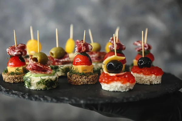 Canapés saborosos na placa de ardósia, close-up — Fotografia de Stock