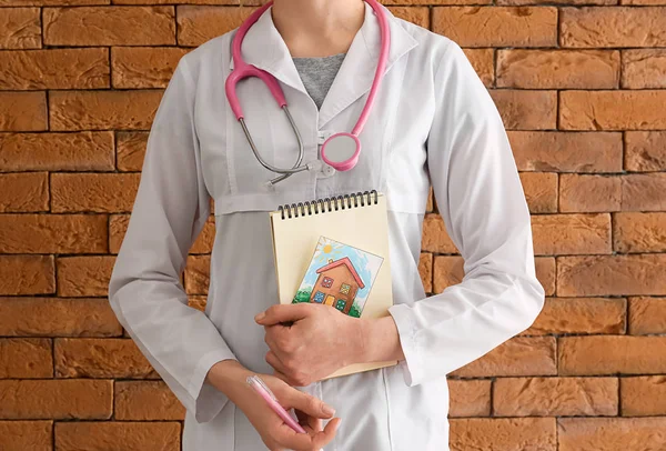 Pediatra femenina sobre fondo de ladrillo — Foto de Stock