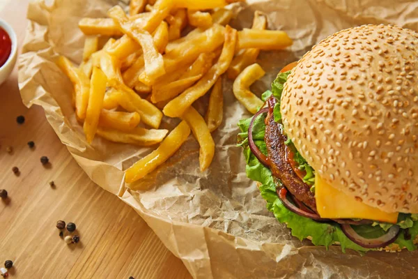 Tasty fresh burger and french fries on table — Stock Photo, Image