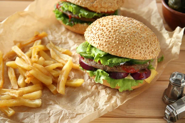 टेबलवर स्वादिष्ट ताजे बर्गर आणि फ्रेंच फ्रीज — स्टॉक फोटो, इमेज