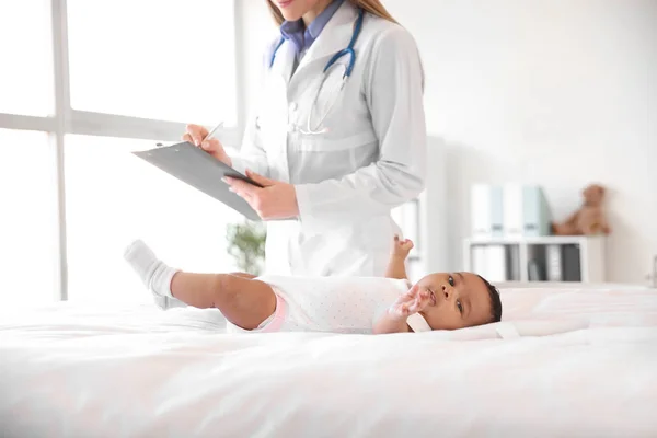 Pediatra examinando bebé afroamericano en clínica — Foto de Stock