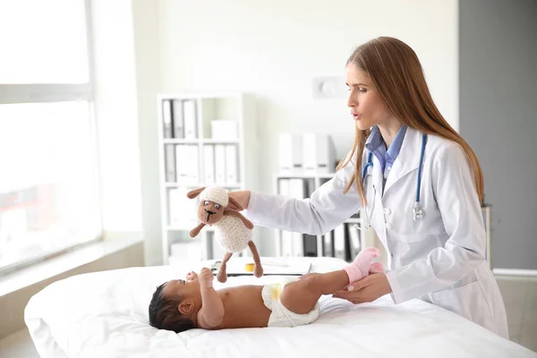 Pediatra examinando bebé afroamericano en clínica — Foto de Stock