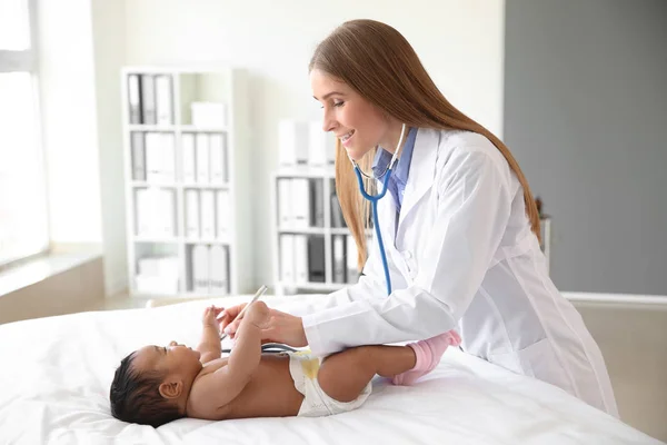 Pediatra examinando bebé afroamericano en clínica —  Fotos de Stock