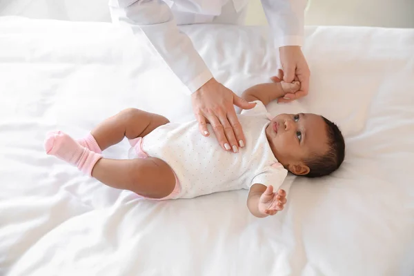 Pediatrician examining African-American baby in clinic — Stock Photo, Image