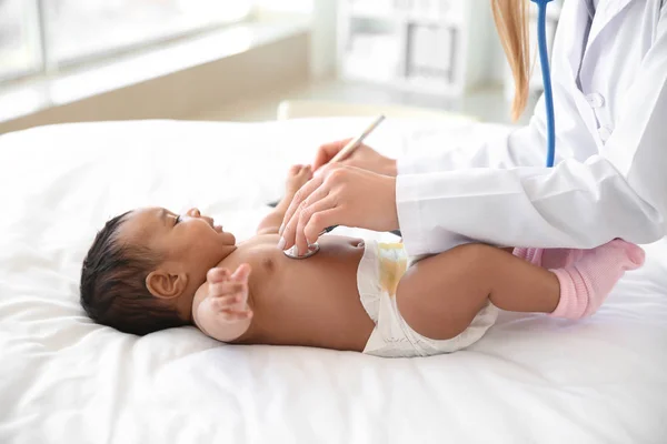 Kinderarts onderzoekt Afro-Amerikaanse baby in kliniek — Stockfoto