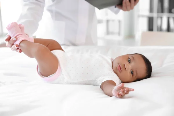 Pediatra examinando bebê afro-americano na clínica — Fotografia de Stock