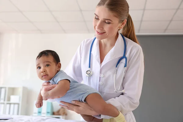 Pediatra examinando bebé afroamericano en clínica —  Fotos de Stock
