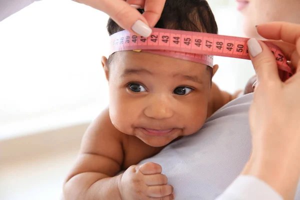 Pediatra examinando bebé afroamericano en clínica — Foto de Stock