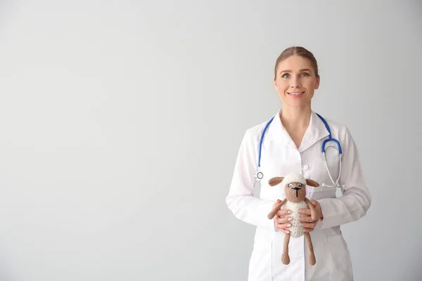 Pediatrician with toy on light background — Stock Photo, Image