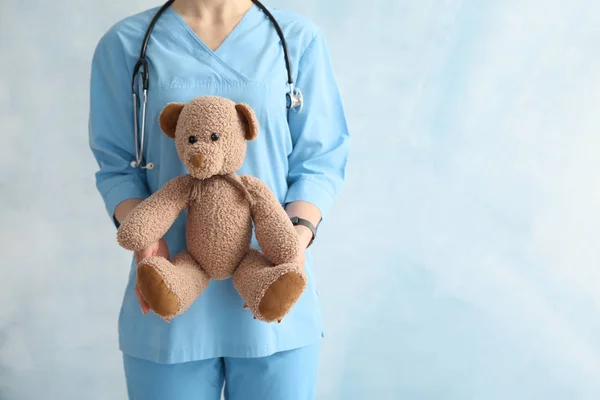 Pediatra con giocattolo su sfondo a colori — Foto Stock