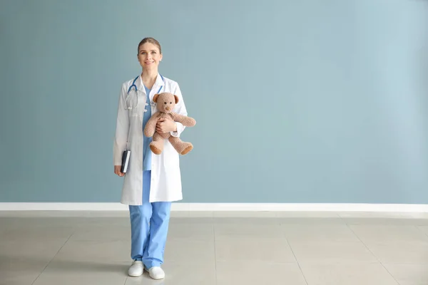 Pediatra con giocattolo vicino alla parete di colore — Foto Stock